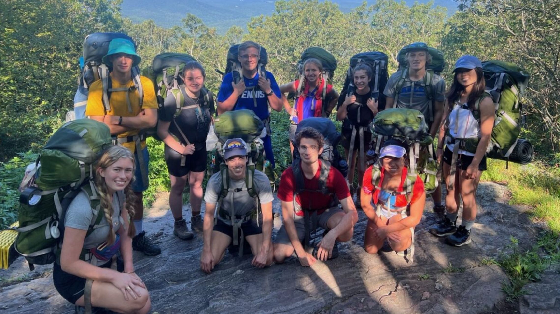 students in backpacks on trail